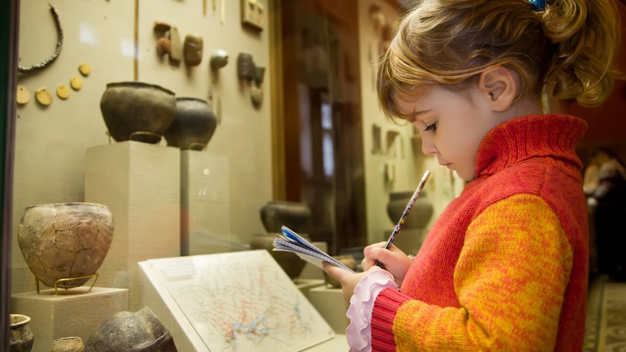 Девочка в музее, записывает информацию в блокнот